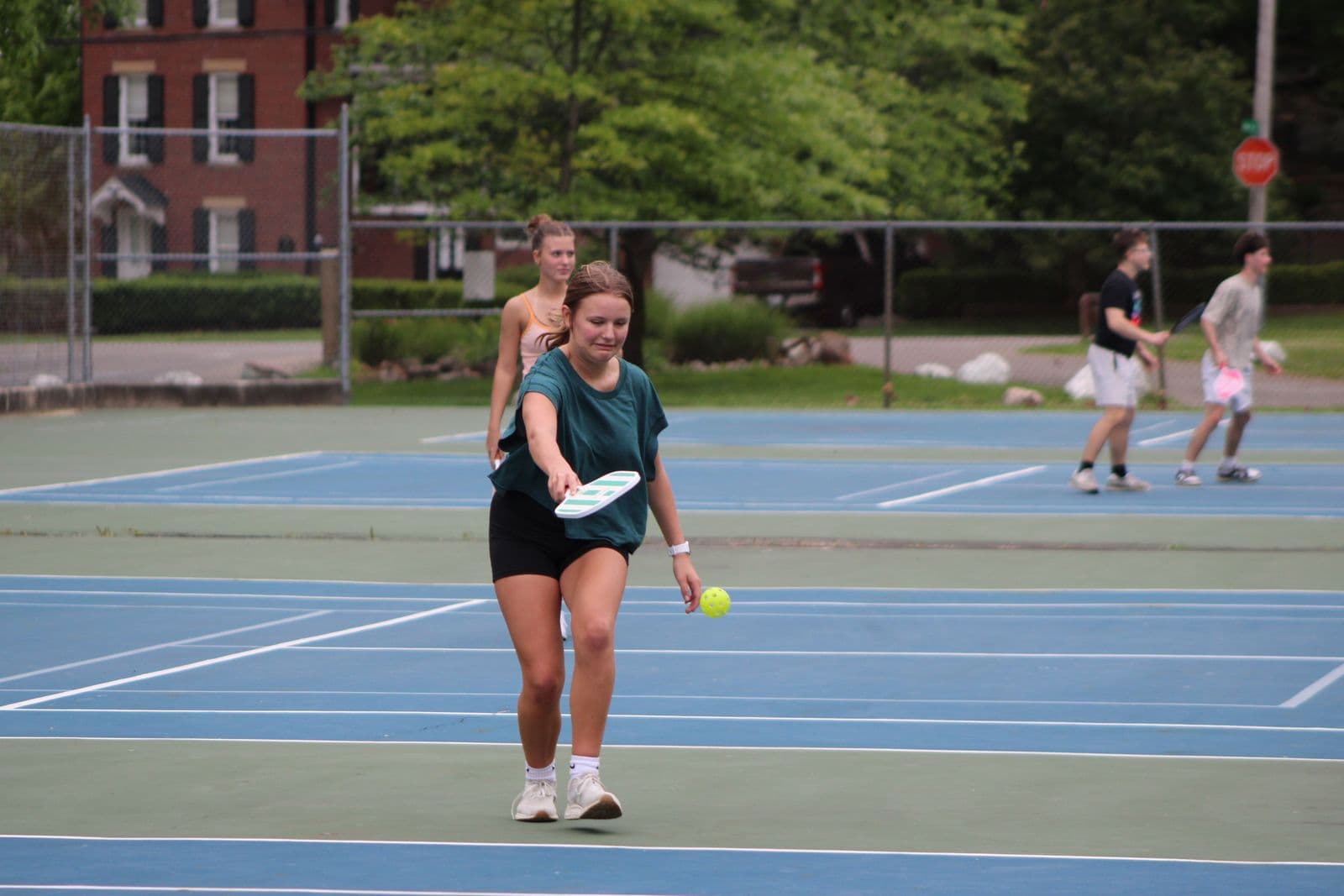 Friends playing pickleball on an outdoor court