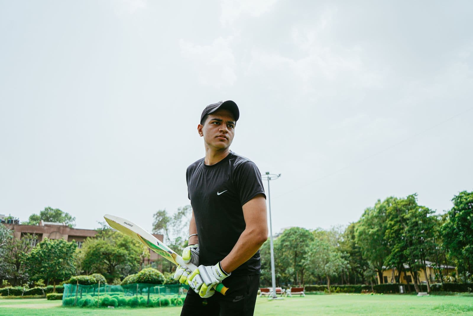 Cricketer preparing with a bat on a green field